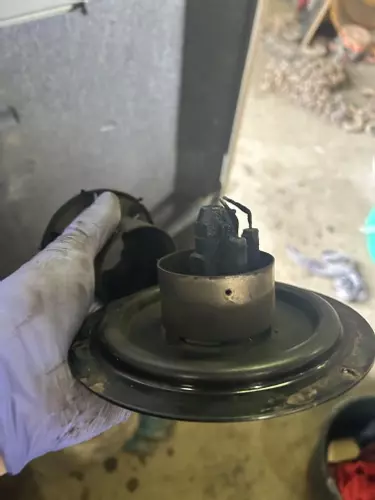 Close-up of heavily carboned burner nozzle and electrodes before servicing on a Nilfisk SH Truck Booster, showing soot build-up affecting combustion.